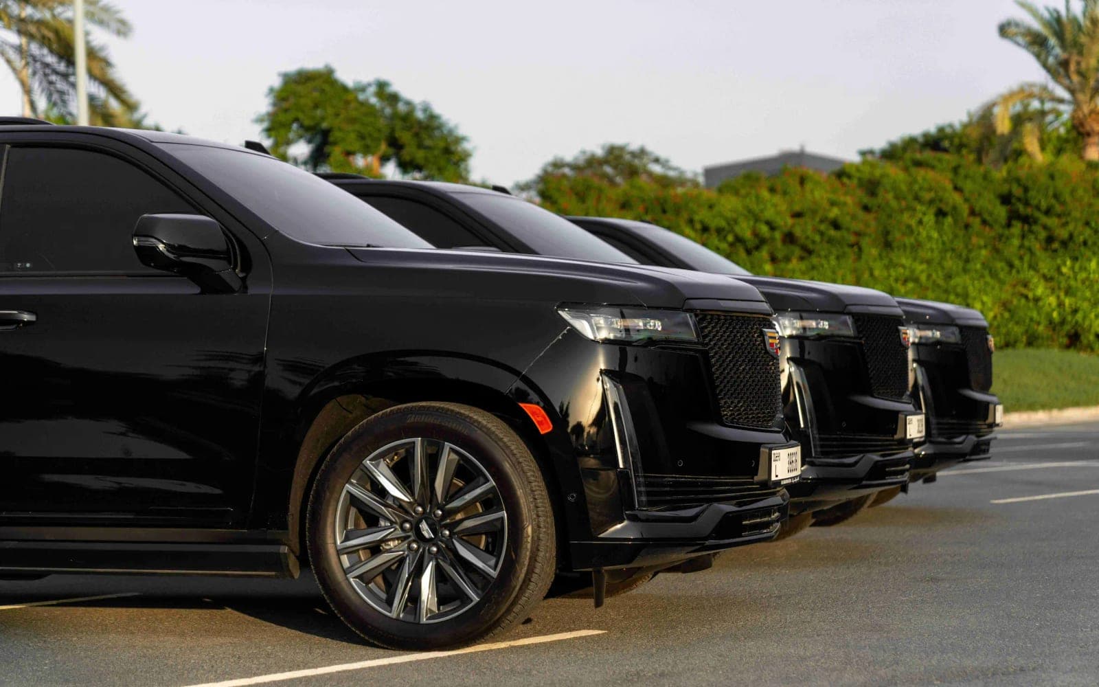Black Cadillac Escalade chauffeur cars lined up ready for Dubai airport transfers