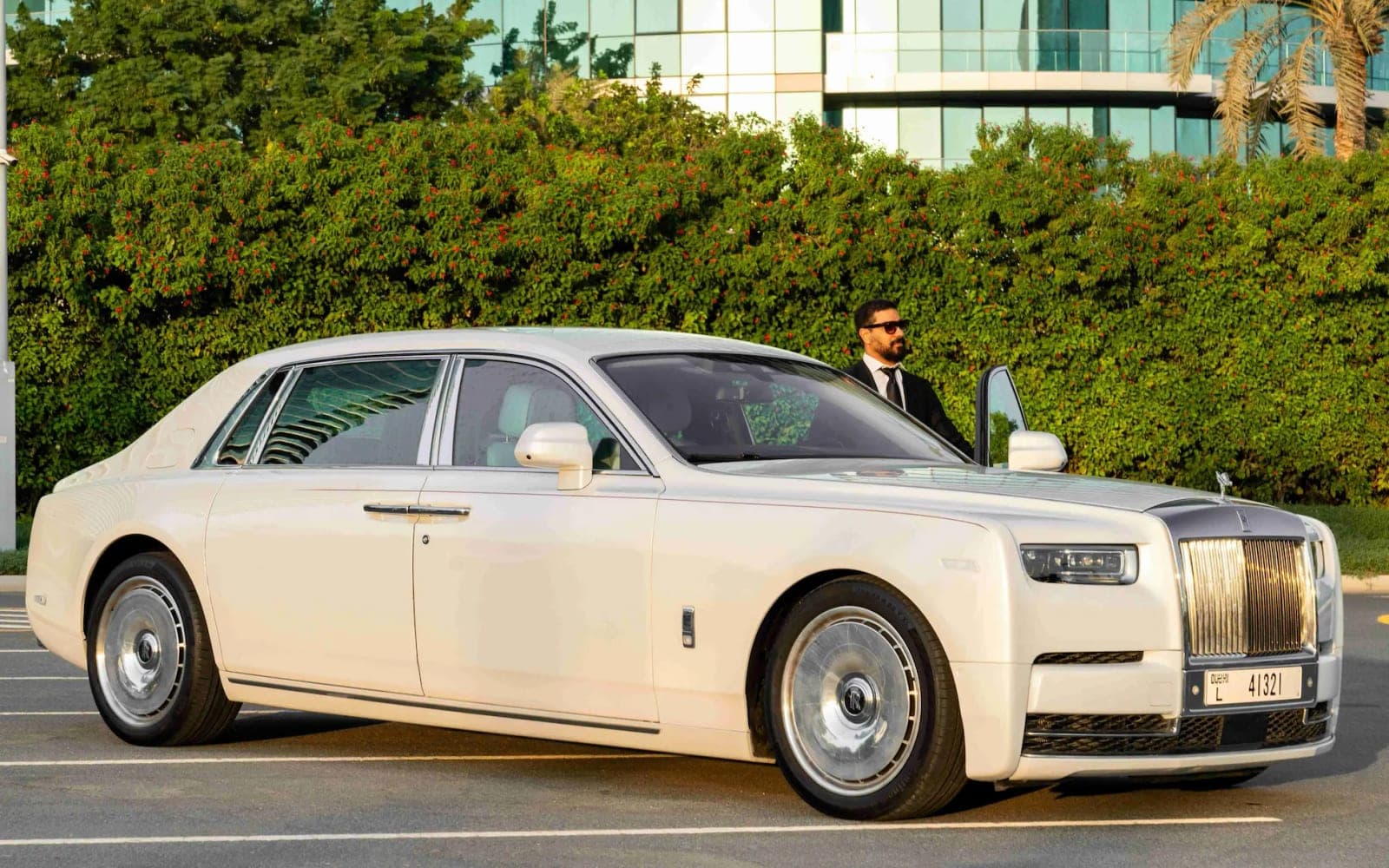 White Rolls-Royce Phantom wedding car with a suited chauffeur holding the door open